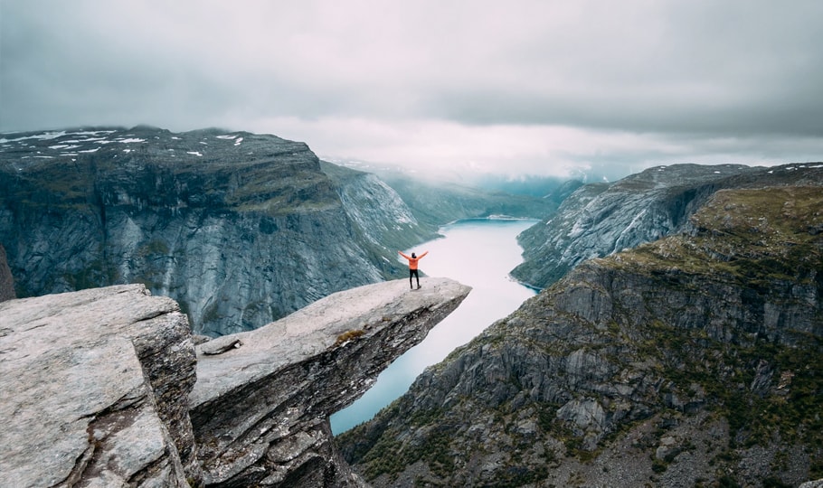 Man standing on a cliff in the mountains wallpapers